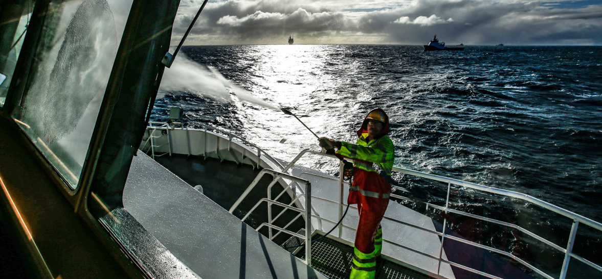 Picture of a man cleaning windows on a ship.