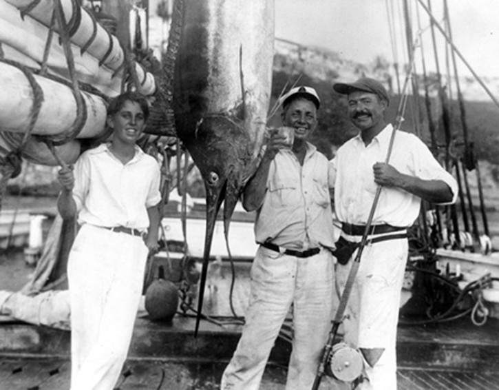 Ernest Hemingway som fikk Nobels litteraturpris poserer med "Sloppy Joe" og en sverdfisk  på en båt i  Havanna havn på Cuba.